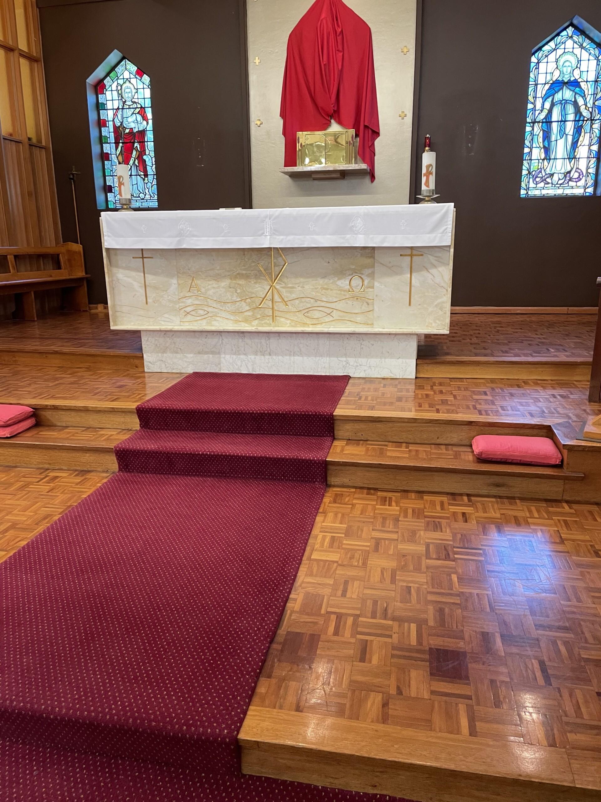 Professional cleaner wiping down a church pew with a disinfectant cloth during a comprehensive church cleaning service